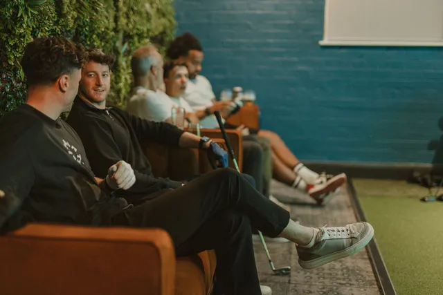 A group of golfers relaxing on the sofas between shots