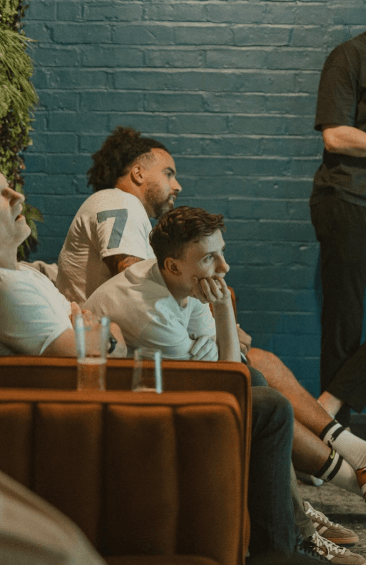 Friends watching live sport on the sofas