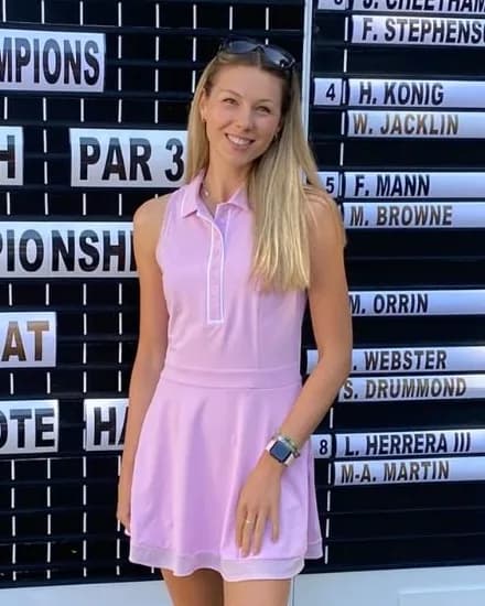 Zara, smiling, in front of a tournament scoreboard