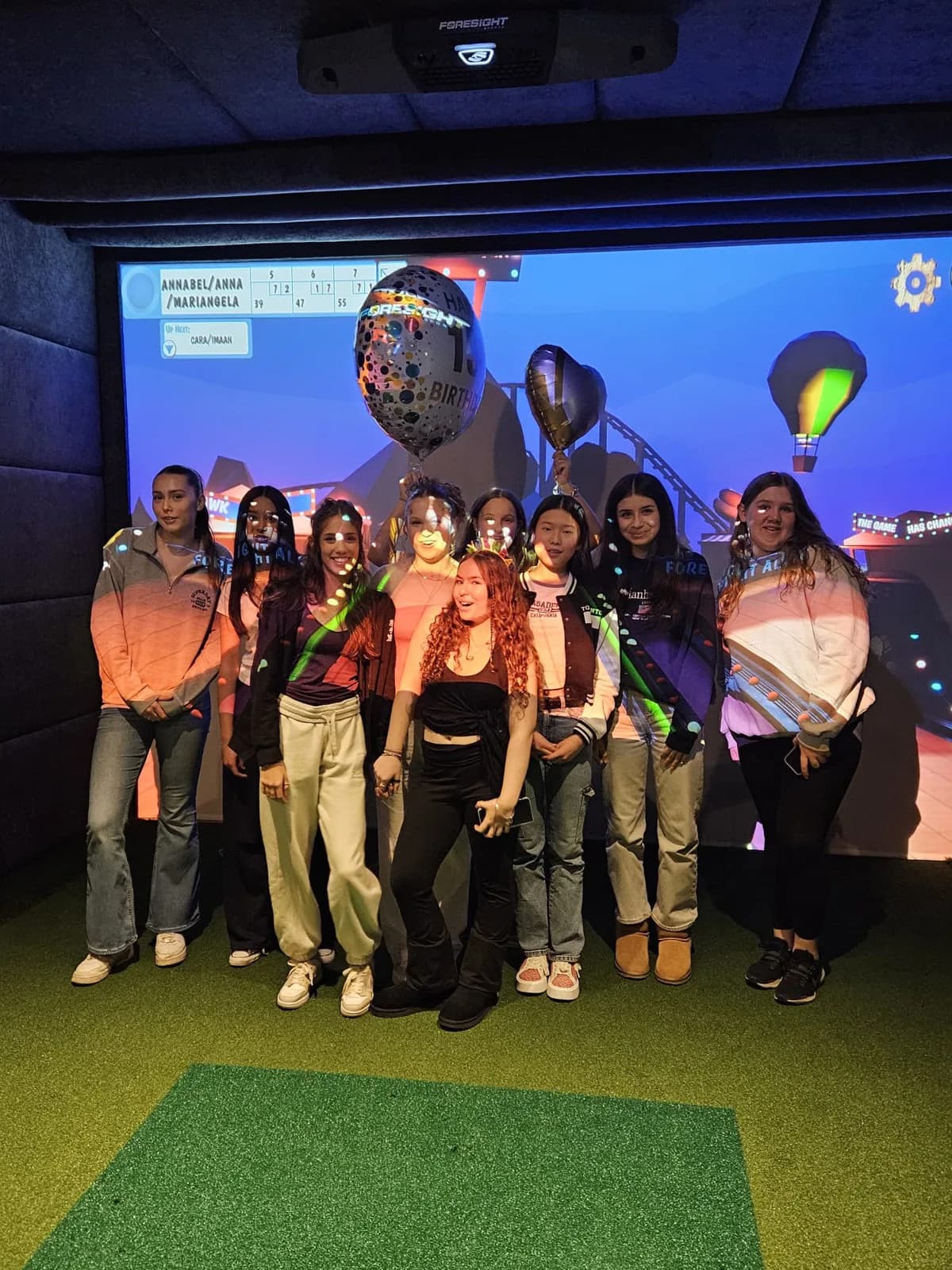 A group with balloons posing in a simulator bay